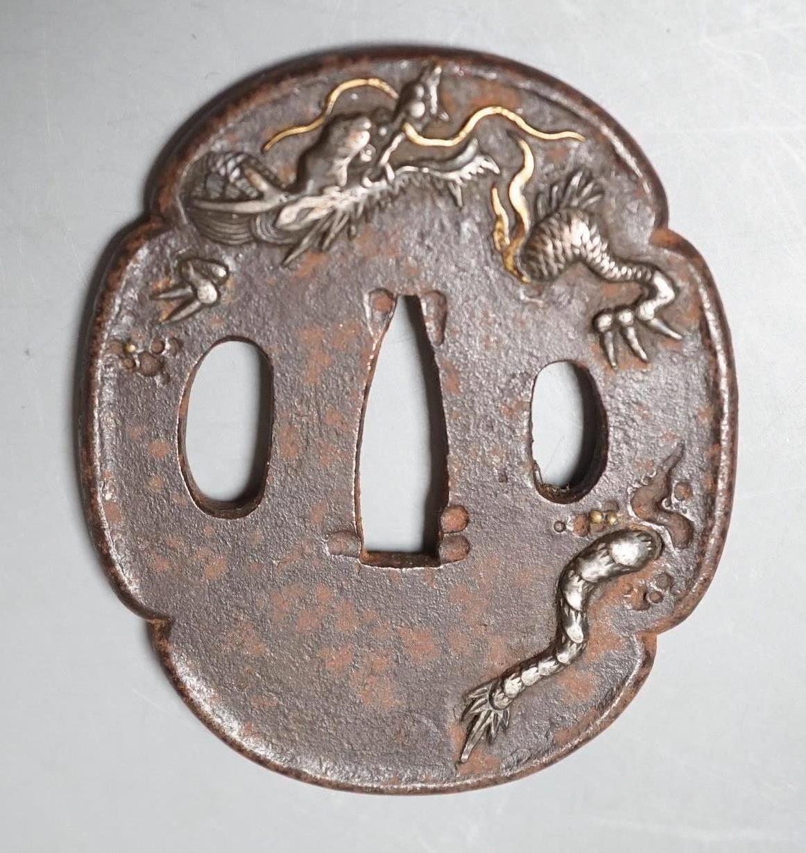 A Japanese Meiji silver and gold overlaid iron tsuba, 6.5cm high